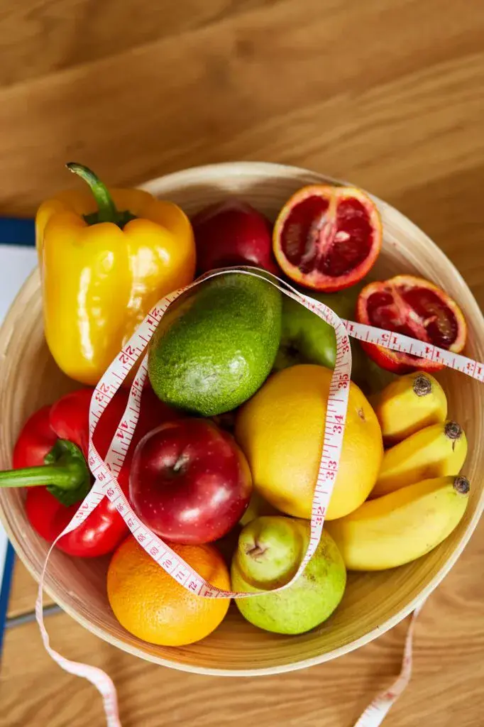 Top view of Nutritionist, dietitian workplace with measuring tape and bowl